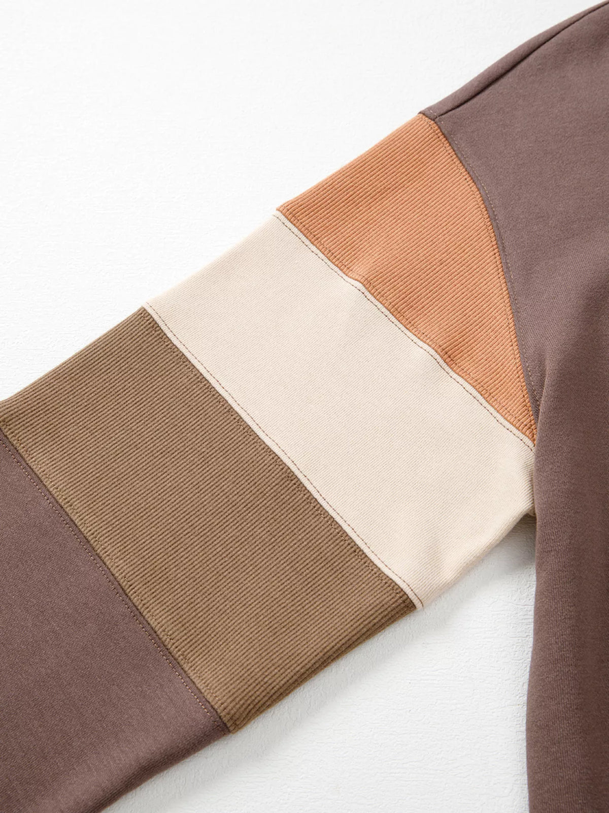 A Change Of Pace Sweatshirt in mocha brown with rust-orange and cream color-block sleeves, shown close up view.