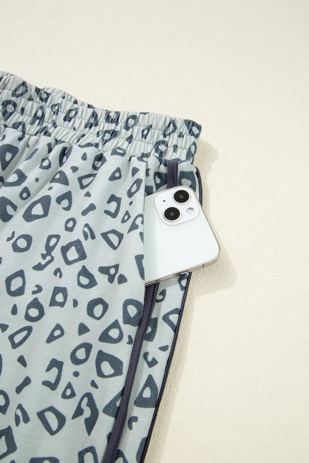 Pants, leopard print, high waist, elastic waistband, no drawstring, piping, side ties, pocketed, gray in color, some stretch close up view