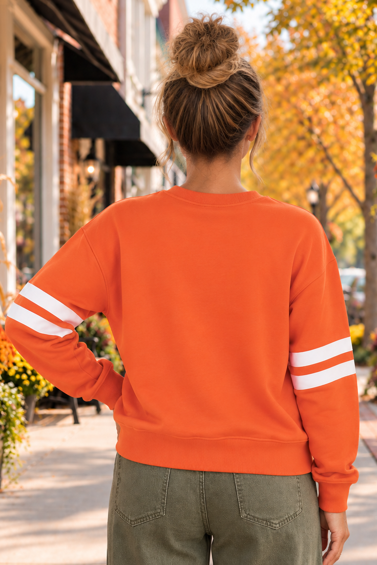 Spooky Season Graphic Sweatshirt in orange with varsity sleeve stripes and three patterned ghosts over black lettering, shown from the back.