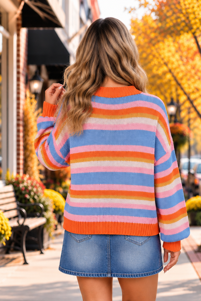 Color Theory Striped Sweater with blue, pink, orange, yellow and white stripes, textured knit, relaxed sleeves and orange ribbed trim.