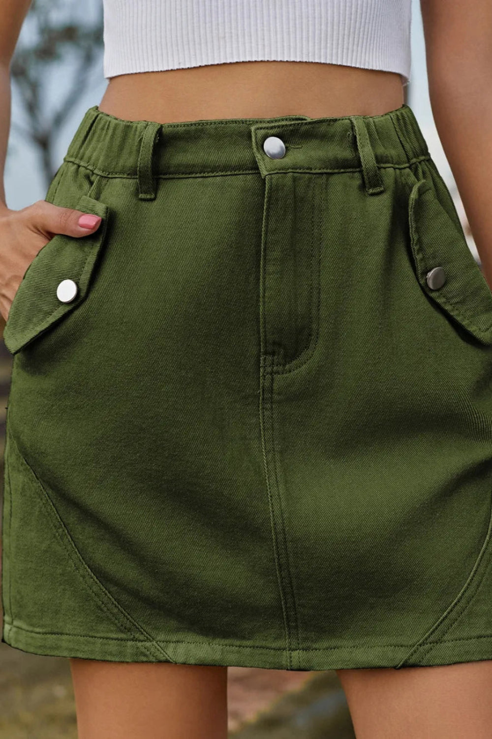 Belt looped, flap pockets, zipper and button closure, elastic waist, denim mini skirt front view