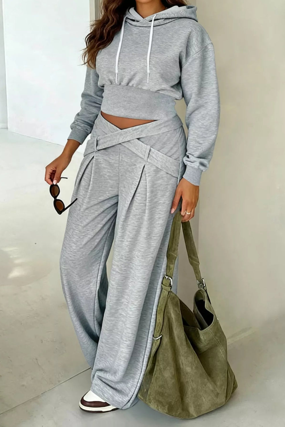 Two-piece activewear set, gray in color, hoodie, drawstring, drop shoulder, long sleeve, cropped, ribbed, wide leg, criss-cross front, slightly stretchy, front view
