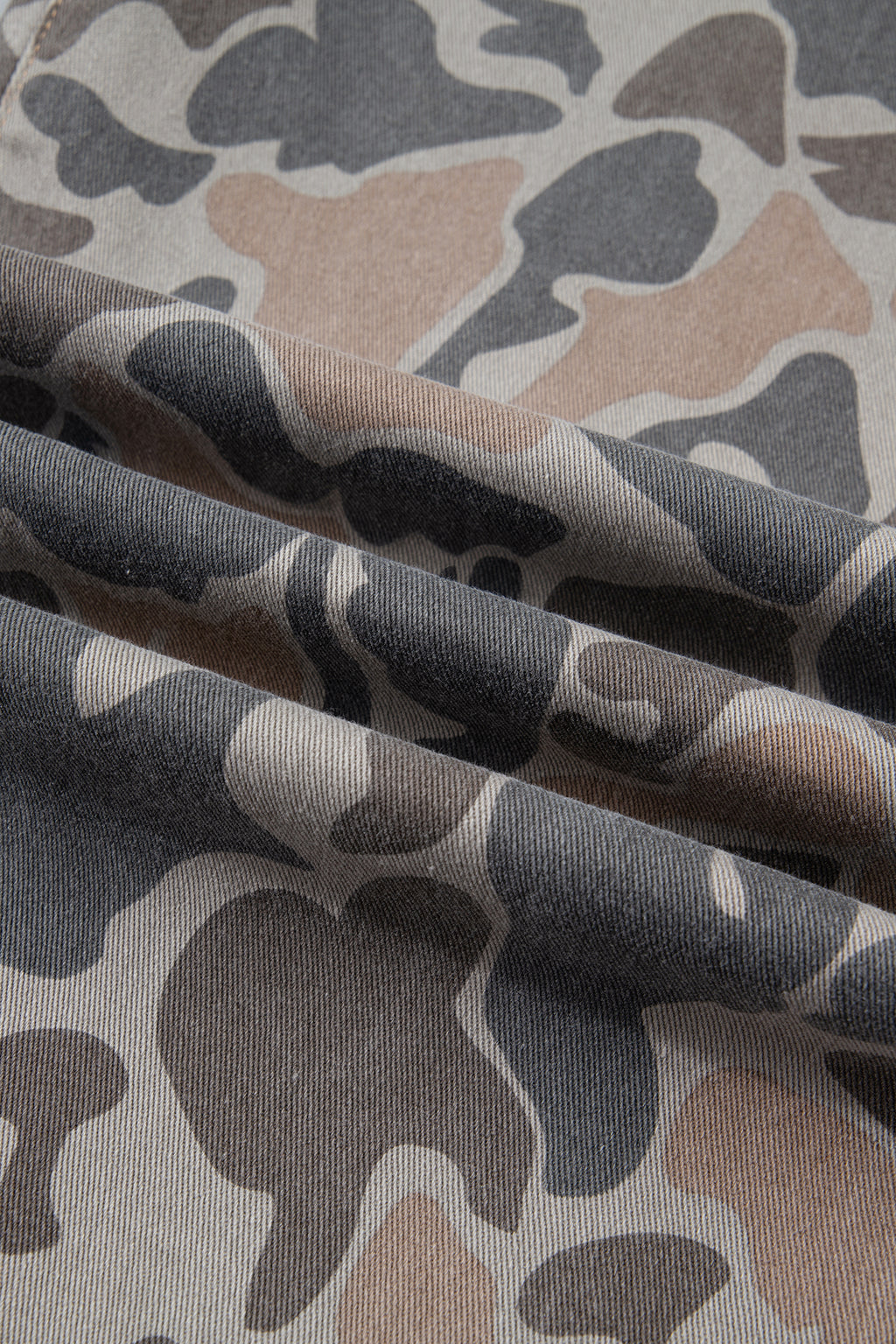 Fabric view close up of the Incognito Jeans in muted taupe and gray camouflage with wide cropped legs and oversized patch pockets.
