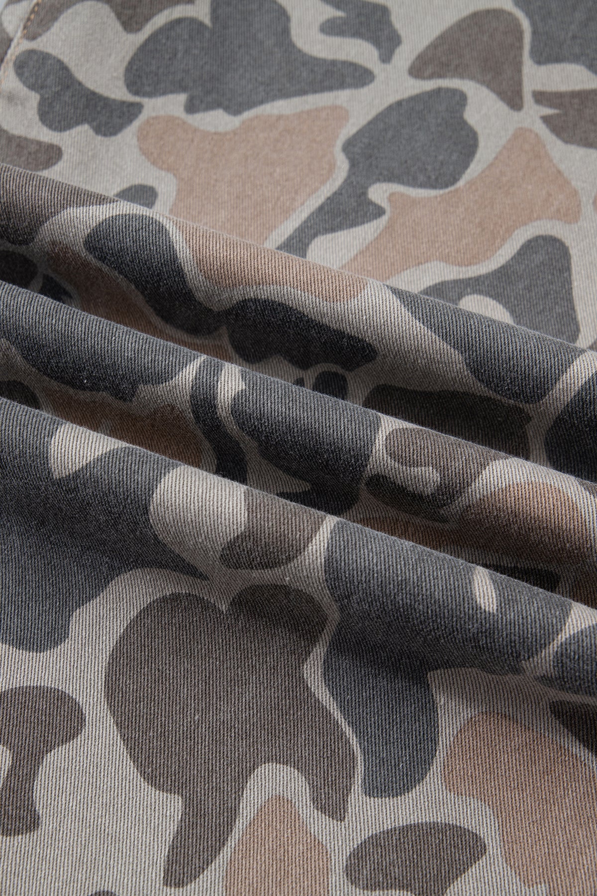 Fabric view close up of the Incognito Jeans in muted taupe and gray camouflage with wide cropped legs and oversized patch pockets.