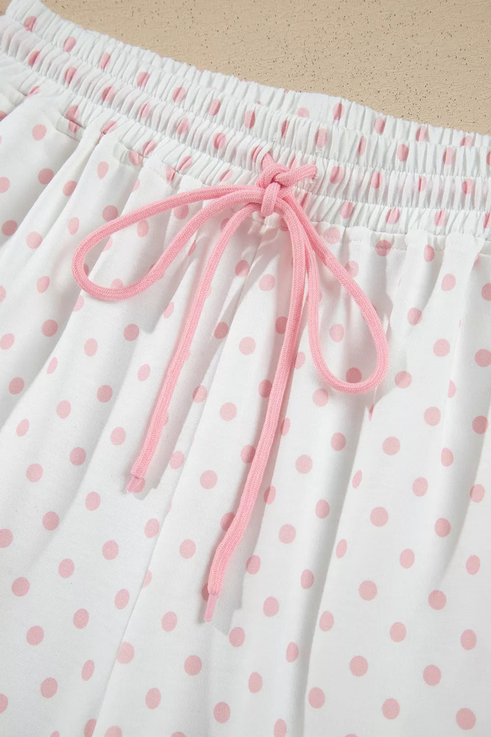 Social Club Pant Set with a light pink cropped sweatshirt, polka-dot shoulder panels, and matching wide-leg drawstring pants close up view.