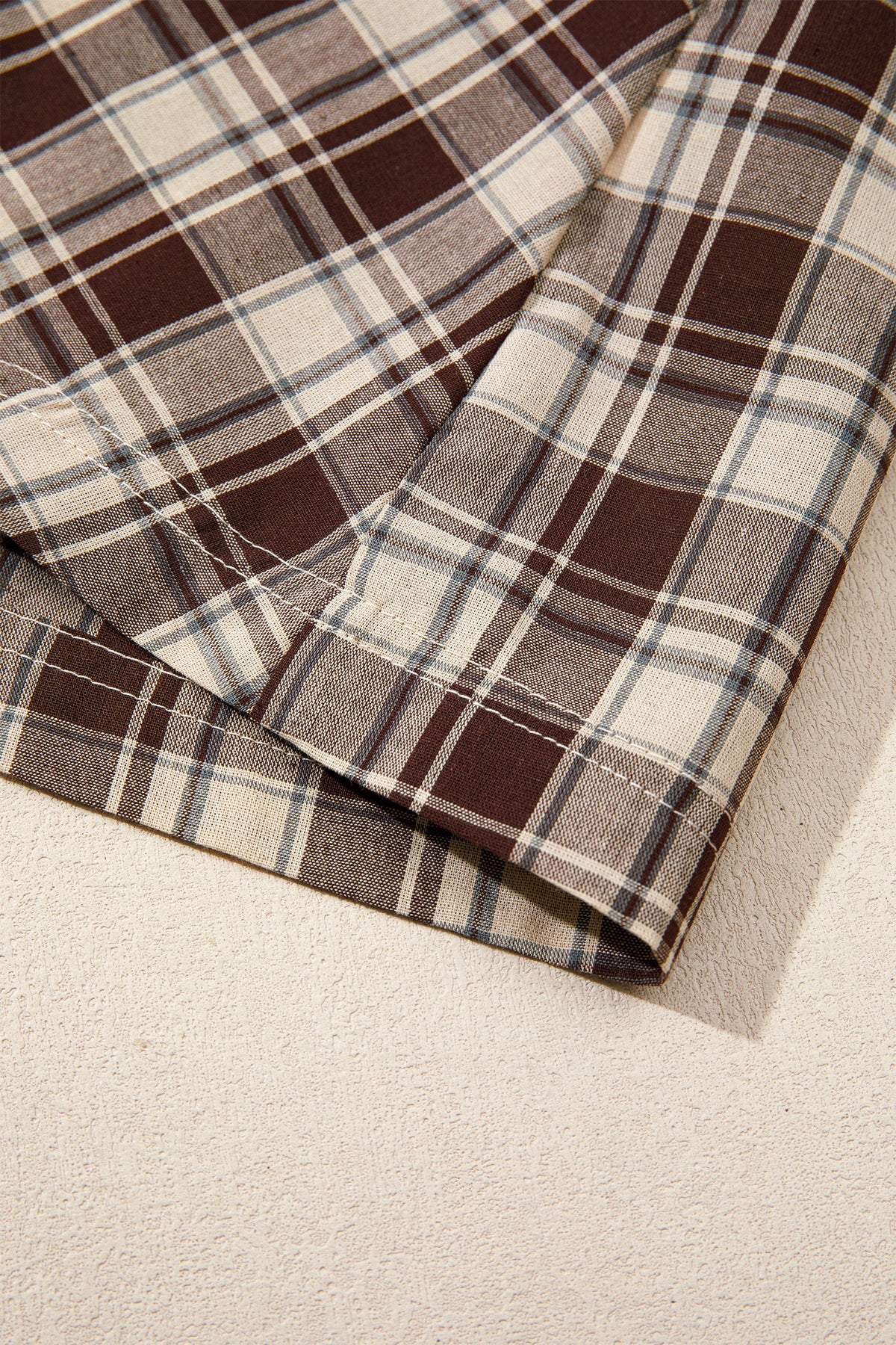 Front view of the Well Thought Of Mini Dress in brown and cream plaid with a collared button front, long sleeves, and pockets.